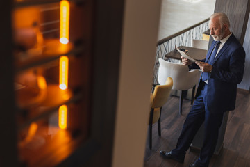 Obraz premium Senior businessman reading newspapers