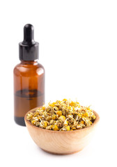 Chamomile Essential Oil with Dried Chamomile Flowers Isolated on a White Background