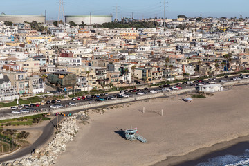 Fototapeta na wymiar Afternoon aerial view of sandy beaches, dense housing and fuel storage tanks in Manhattan Beach, near Los Angeles, California. 