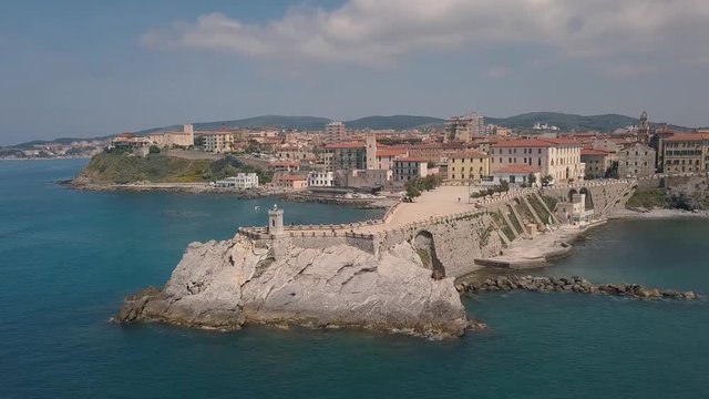 Aerial view of the coast of Piombino. Flight over the sea and pier. Maremma Tuscany Italy.