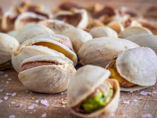 Pistachioes on the wooden and blurry background salty close up