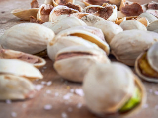 Pistachioes on the wooden and blurry background salty close up