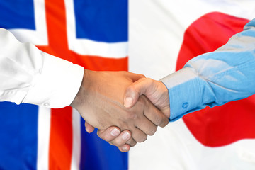 Business handshake on the background of two flags. Men handshake on the background of the Iceland and Japan flag. Support concept