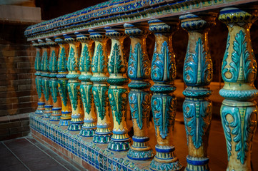 Fototapeta premium Seville, Spain. Detail of the balustrade in blue and yellow decorated ceramic. Night background