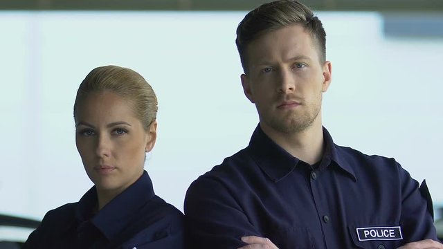 Young police officers posing on camera, looking serious and brave on duty