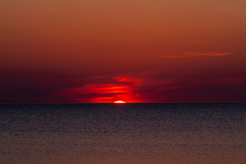 Sunrise red spring sun from the water of the lake