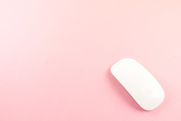 White laptop mouse over pink background.