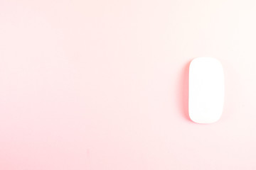 White laptop mouse over pink background.