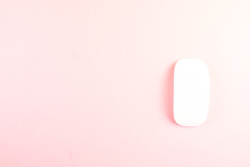 White laptop mouse over pink background.