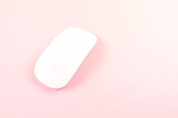 White laptop mouse over pink background.