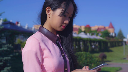 Portrait young asian woman using app on smart phone. Attractive female standing on the street and...