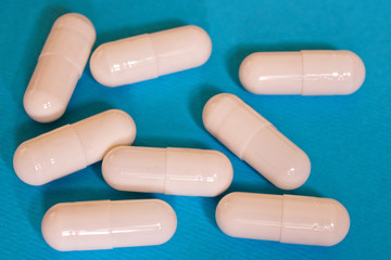 The capsules with the medicine are on a blue background