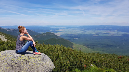 Naklejka premium Young woman enjoying picturesque view of the mountains, freedom and relaxation concept