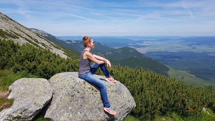 Naklejka na ściany i meble Young woman enjoying picturesque view of the mountains, freedom and relaxation concept