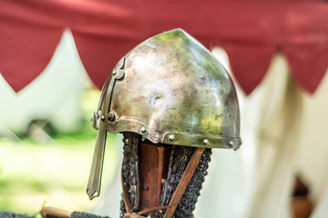 Knightly medieval metal helmet on the stand. Old dark ages armor and equipment for knights head...