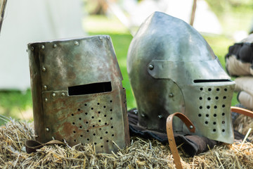 Knightly medieval metal two helmets on the stand. Old dark ages armor and equipment for knights...