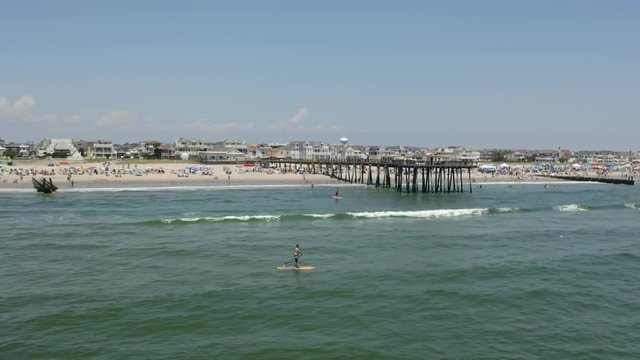 Paddleboarder in ocean by pier Atlantic 