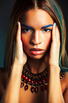 young pretty modern african american girl with bright fashion makeup and ethnic jewelry closeup
