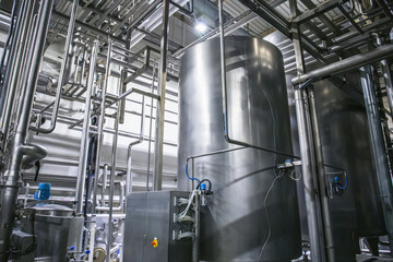 Stainless steel brewing equipment, iron reservoirs or tanks and pipes in modern beer factory. Brewery production concept, industrial background