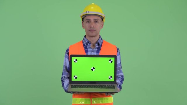Stressed multi ethnic man construction worker showing laptop