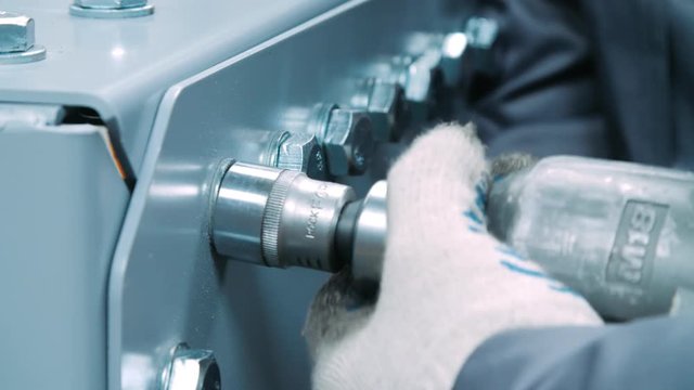 Master working with screwdriver during assemble at factory. Industrial tool