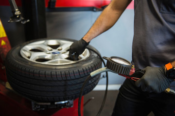 Man using the manometer to inflate a new tire in the garage