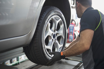 car mechanic placing the rear wheel in place