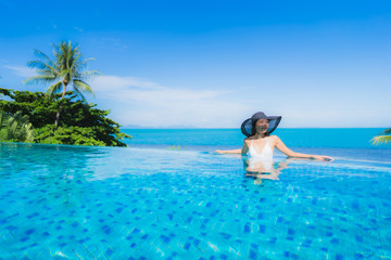 Portrait beautiful young asian woman relax in luxury outdoor swimming pool in hotel resort nearly beach sea ocean