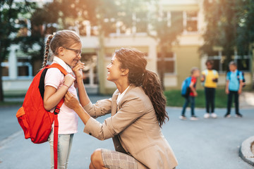 First day at school. Mother leads a little child school girl in first grade.