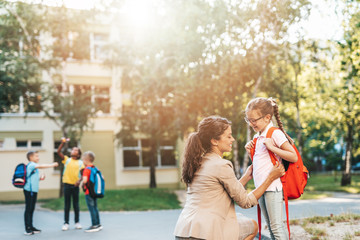 First day at school. Mother leads a little child school girl in first grade.