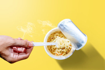 People eat the instant cup noodles with fork