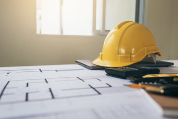 High angle view of housing plan blueprint with yellow safety helmet.