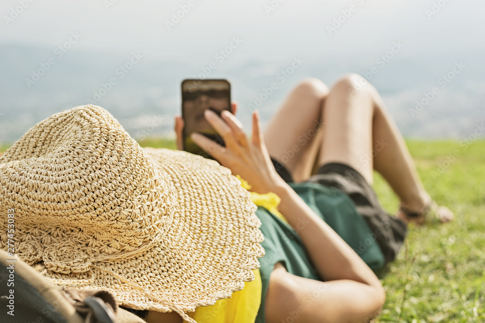 Canvas Prints woman lie on grassland and using cellphone