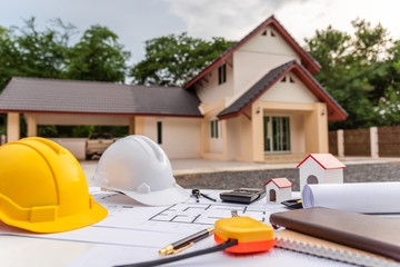 Architect desk with blueprint and hard hat constuction building.