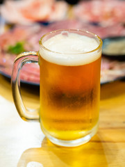 beer and slice beef for grill on wooden table : Selective focus.