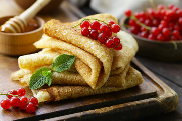 thin pancakes with berries and honey