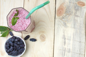 Refreshing vitamin cocktail of honeysuckle berries with a sprig of mint close-up, top view.