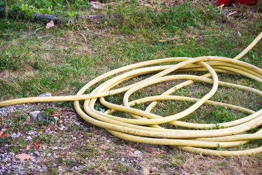 Treviso, Italy, 06/23/2019,  water hose in a backyard in a countryside house in north of Italy.