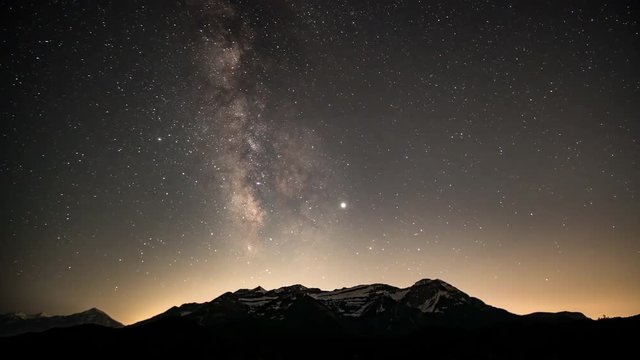 Time lapse from night to day viewing the galaxy as the stars and Milky Way move over Timpanogos Mountain through the night as the sun shines on the peaks.