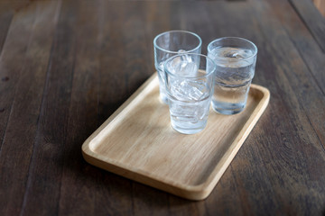 Glass of cold water placed on a wooden table