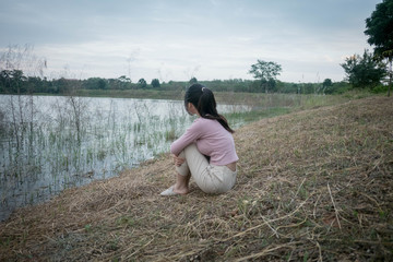 Sad young girl sitting alone outdoors. Teenage girl thinking thoughtfully. Hope. Sadness. Loneliness