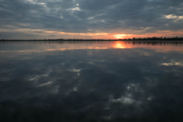 Dark blue - orange with clouds at sunset The orange sun falls behind the horizon. Behind the scenes Natural background