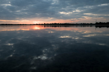 Dark blue - orange with clouds at sunset The orange sun falls behind the horizon. Behind the scenes Natural background