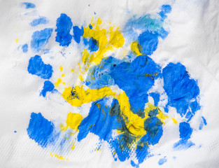 Abstract background. Yellow and blue color spots on white paper, close up view. Inkblots on white background. Abstract drawing. Paint blotch on white