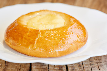 Appetizing cheesecake with cottage cheese on a white plate. Homemade pastry, bun with stuffing