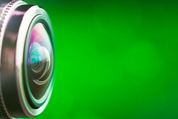 Camera lens with green backlight. Side view of the lens of camera on green background. Greencamera Lens close Up. Pure red