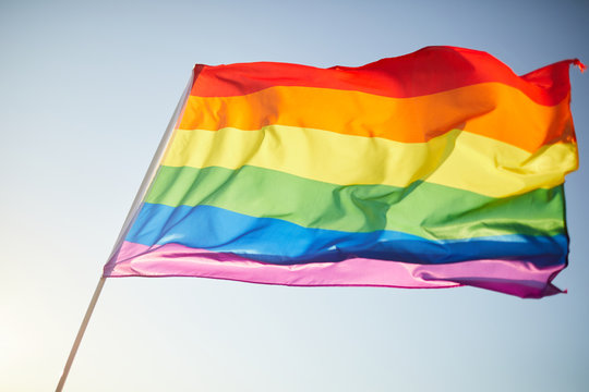 Close-up of bright multi-colored rainbow flag waving in breeze, background image