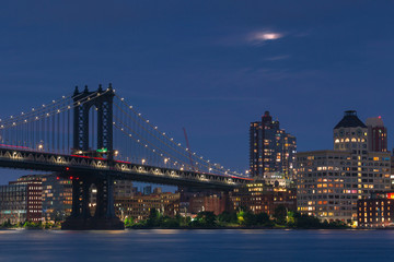 Fototapeta premium Manhattan Bridge and Dumbo from East River with full moon at night ,with long exposure photo