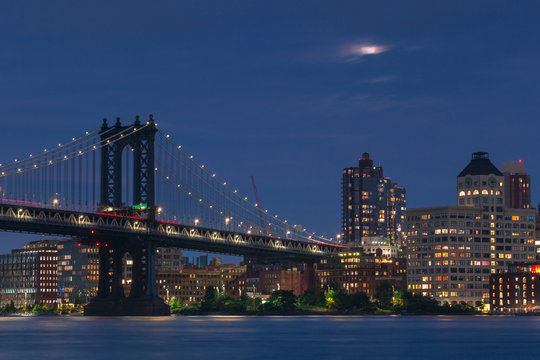 Manhattan Bridge and  Dumbo from East River with full moon at night ,with long exposure photo