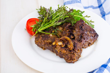 Fried beef liver with lettuce mix. 